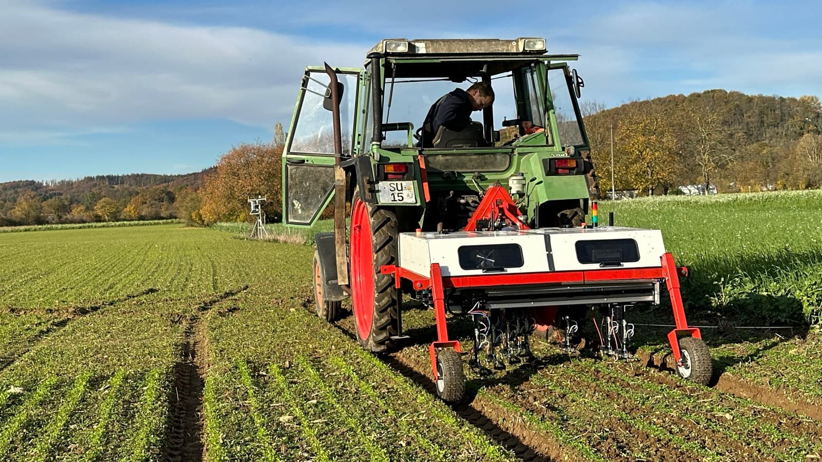 Système de désherbage de précision WeWeed au travail dans les rangs de culture, avec traitement plante par plante monté sur tracteur.
