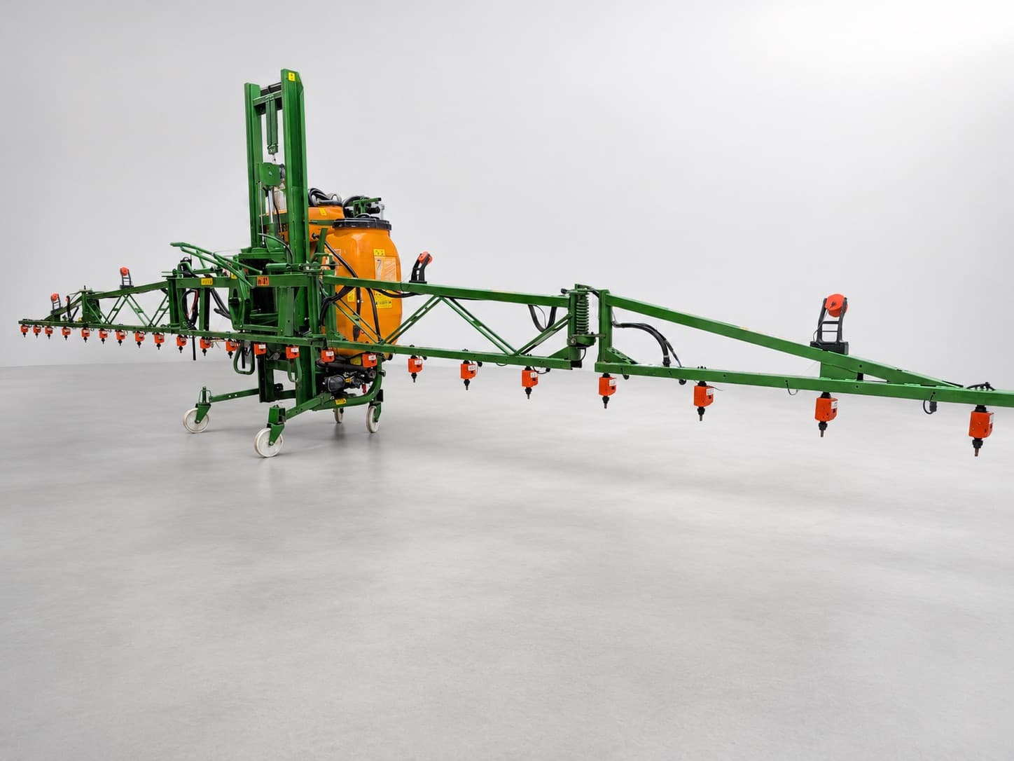 A sprayer boom fitted with the full WeSee retrofit — cameras on brackets along the boom and an orange WeSee unit on every nozzle.