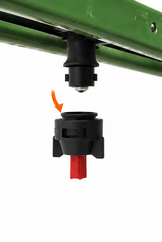 The original nozzle cap coming off the nozzle body under a green sprayer boom.